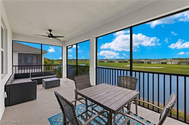 sunroom / solarium featuring a water view and ceiling fan