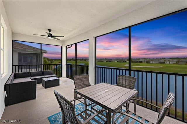 sunroom with a water view and ceiling fan