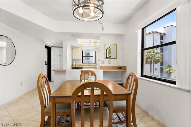 dining area featuring light tile patterned floors, an inviting chandelier, and a healthy amount of sunlight