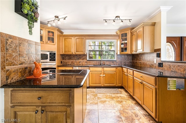 kitchen featuring decorative backsplash, stainless steel microwave, kitchen peninsula, and sink