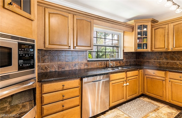 kitchen featuring sink, stainless steel appliances, crown molding, dark stone counters, and light tile patterned flooring