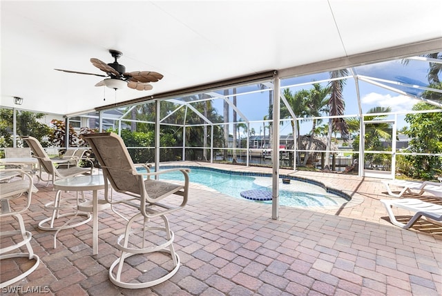 view of swimming pool with ceiling fan, a patio area, and a lanai