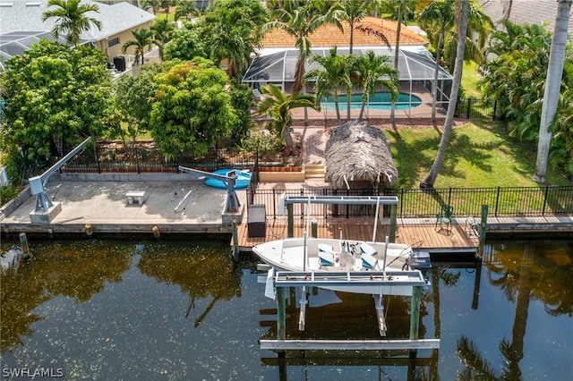 dock area featuring a yard, a water view, glass enclosure, and a fenced in pool