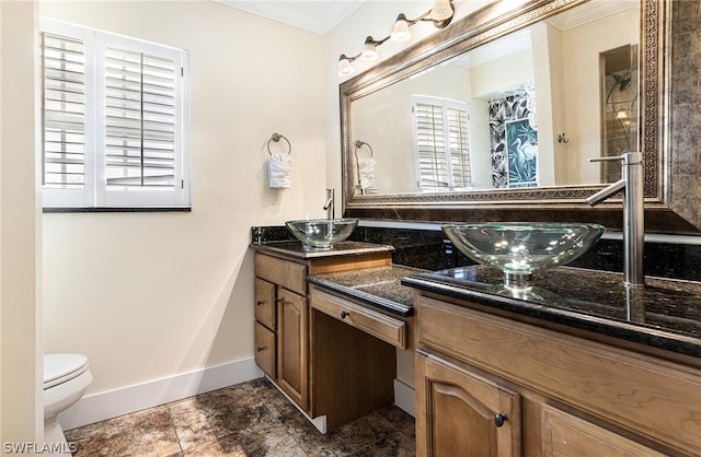 bathroom with vanity, toilet, and ornamental molding