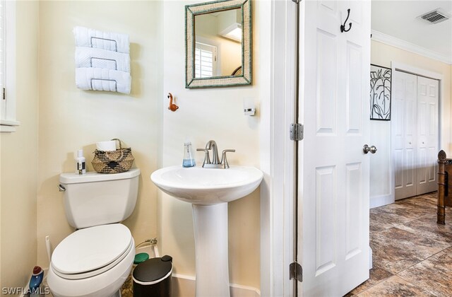 bathroom featuring sink, toilet, and ornamental molding