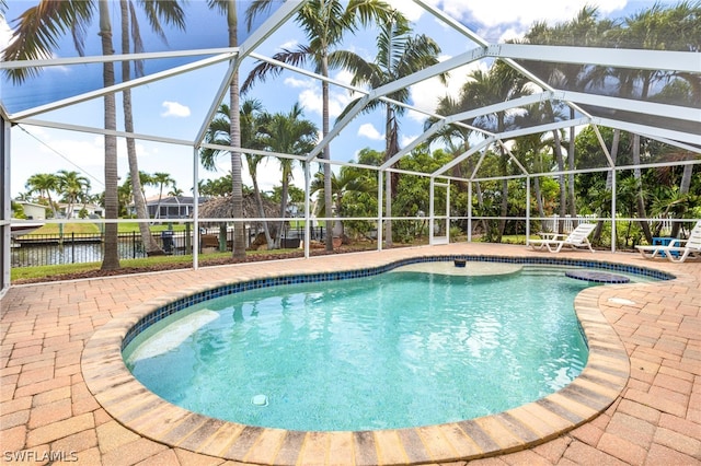 view of swimming pool featuring a lanai, a patio area, and a water view