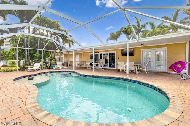 view of pool featuring french doors, a lanai, and a patio area