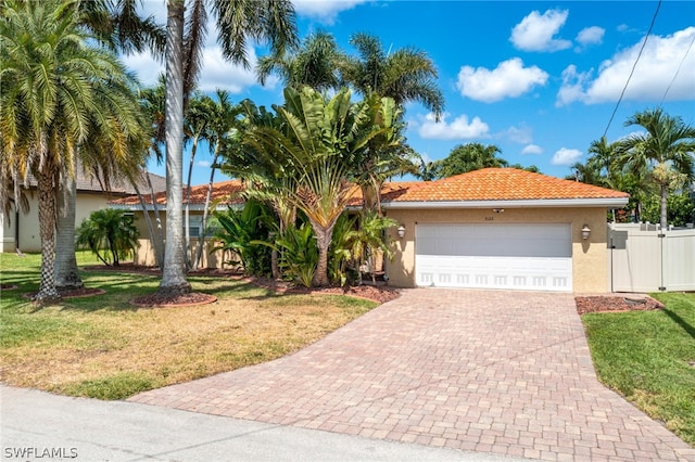 mediterranean / spanish-style house with a front yard and a garage