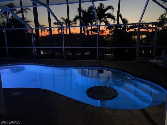 pool at dusk with a lanai