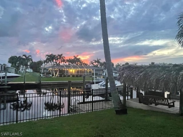 view of dock with a yard and a water view