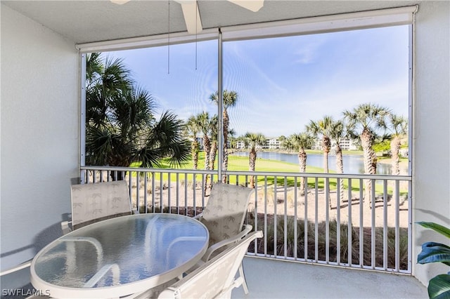 balcony featuring a water view and ceiling fan