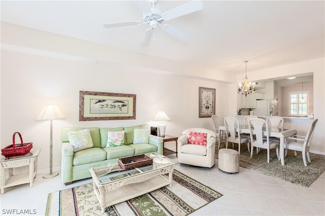 living room with ceiling fan with notable chandelier and light tile patterned floors