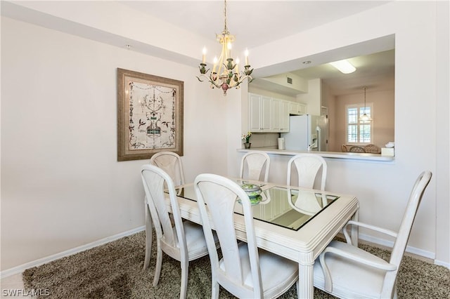 dining area featuring carpet floors and an inviting chandelier