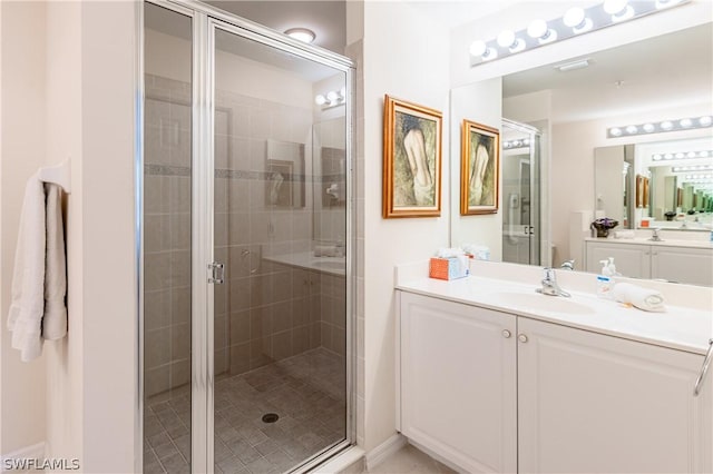 bathroom featuring vanity and a shower with door