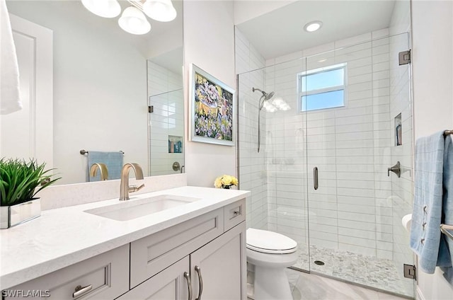 bathroom with vanity, an enclosed shower, and toilet