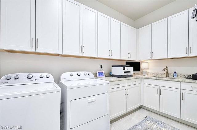 clothes washing area featuring cabinets, separate washer and dryer, and sink