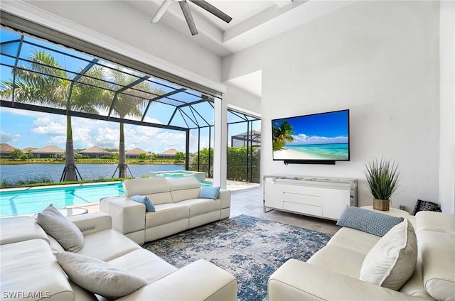 sunroom featuring ceiling fan and a water view