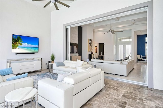 living room featuring french doors, ceiling fan, and a high ceiling