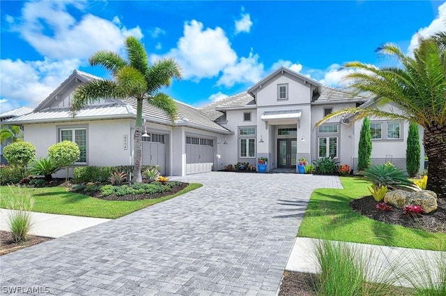 view of front of property with french doors, a garage, and a front lawn