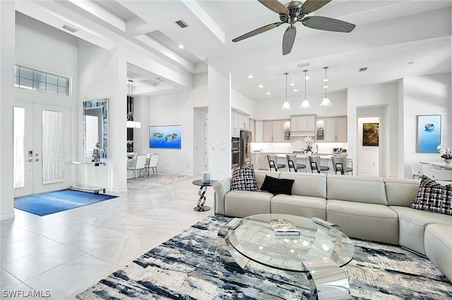 living room featuring ceiling fan, a high ceiling, and french doors