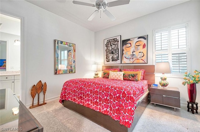 carpeted bedroom featuring ceiling fan and ensuite bath