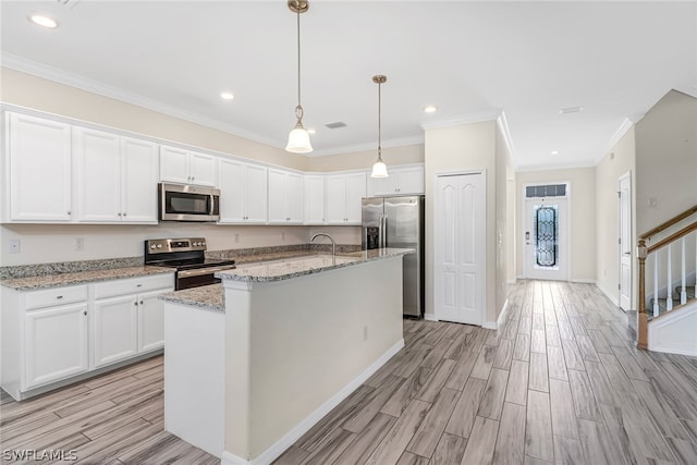 kitchen featuring a center island with sink, white cabinetry, and appliances with stainless steel finishes