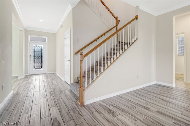 foyer entrance with crown molding and light hardwood / wood-style floors