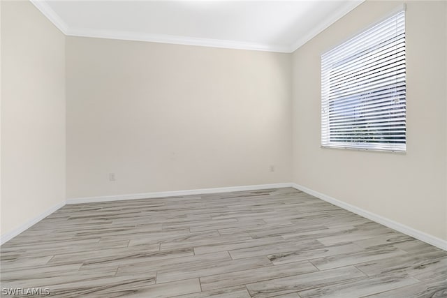 empty room with light hardwood / wood-style floors and crown molding