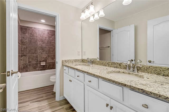 full bathroom featuring vanity, toilet, wood-type flooring, and tiled shower / bath combo