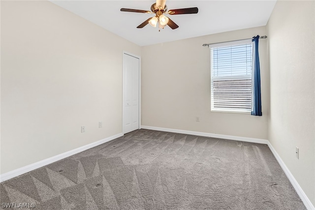 unfurnished room featuring ceiling fan and carpet floors