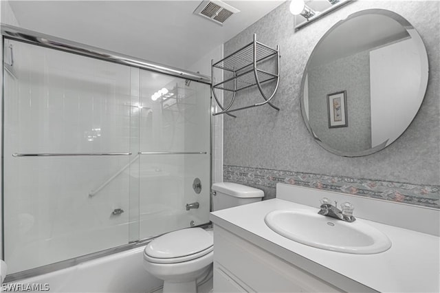 full bathroom featuring enclosed tub / shower combo, vanity, and toilet