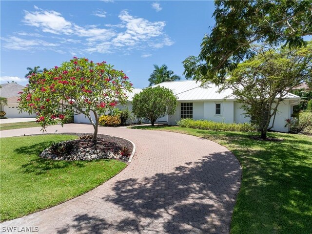 ranch-style home featuring a front yard and a garage