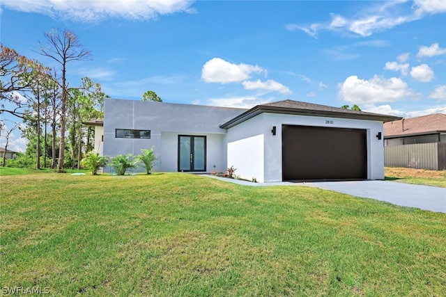 contemporary home featuring french doors, a front yard, and a garage