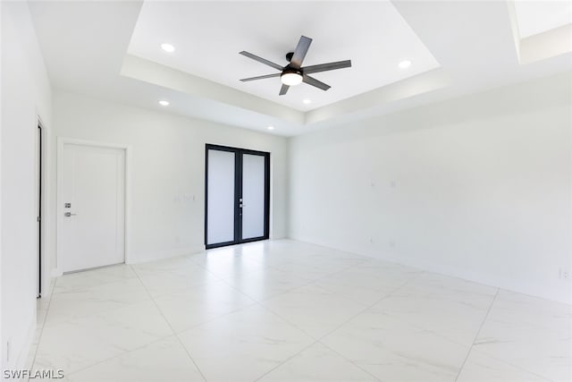 spare room featuring ceiling fan, french doors, and a tray ceiling