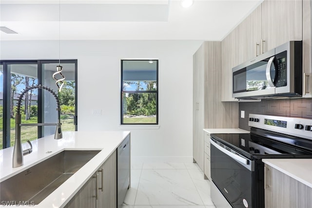 kitchen with decorative backsplash, light brown cabinets, sink, and appliances with stainless steel finishes