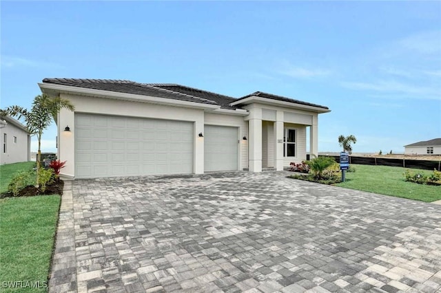 prairie-style house featuring a garage and a front lawn