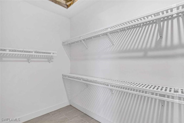 spacious closet featuring lofted ceiling and light tile patterned flooring