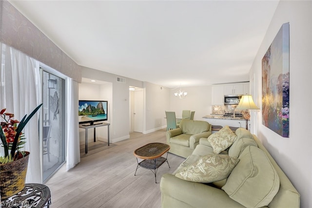 177 Santa Clara Dr Unit 177-4, Naples, FL 34104 - living room featuring light wood-type flooring and an inviting chandelier