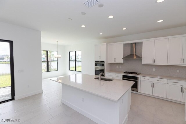 kitchen with backsplash, wall chimney range hood, light tile patterned floors, and a healthy amount of sunlight