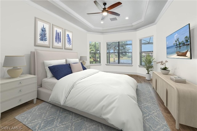 bedroom featuring visible vents, crown molding, a tray ceiling, recessed lighting, and dark wood-style flooring