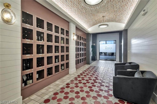 wine cellar featuring brick ceiling, wood walls, and vaulted ceiling