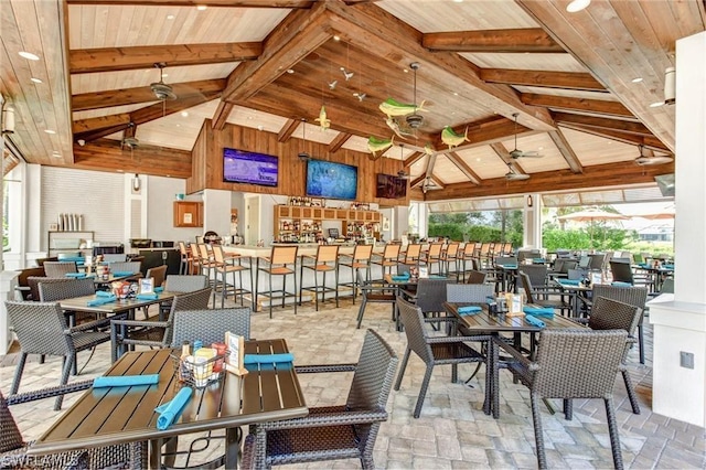 dining space featuring beamed ceiling, wood ceiling, and stone finish floor