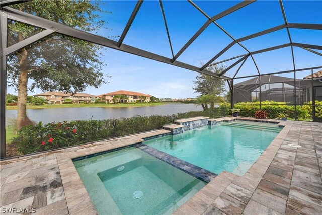 view of pool featuring glass enclosure, a water view, an in ground hot tub, and a patio