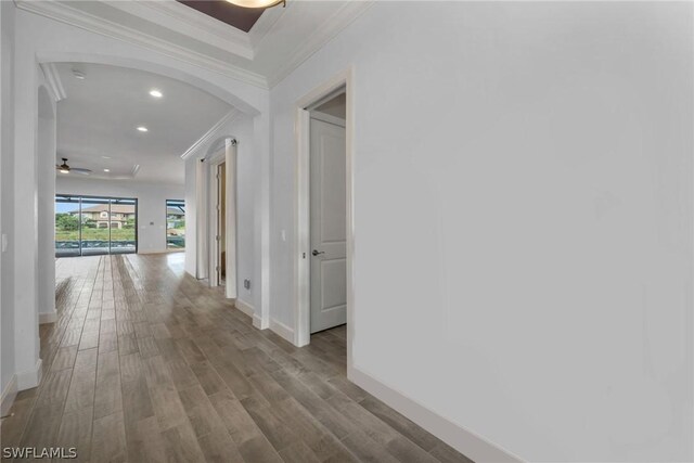 hallway with light hardwood / wood-style flooring and ornamental molding