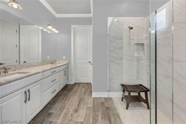 bathroom with wood tiled floor, ornamental molding, walk in shower, and a sink