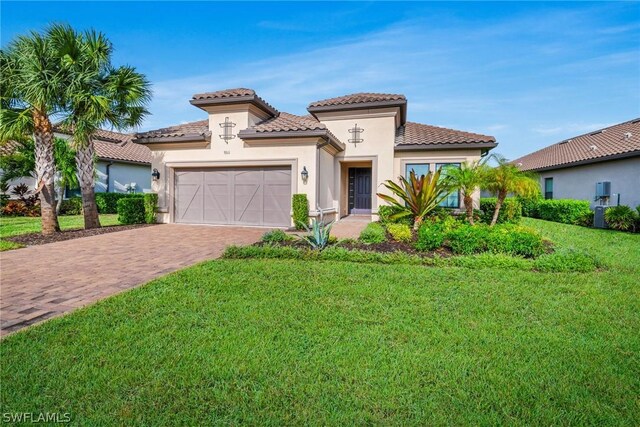 mediterranean / spanish-style home with a front lawn and a garage