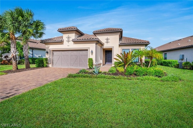 mediterranean / spanish house with stucco siding, a front lawn, a tile roof, decorative driveway, and an attached garage