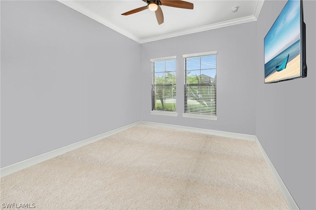 carpeted spare room featuring ceiling fan, baseboards, and ornamental molding