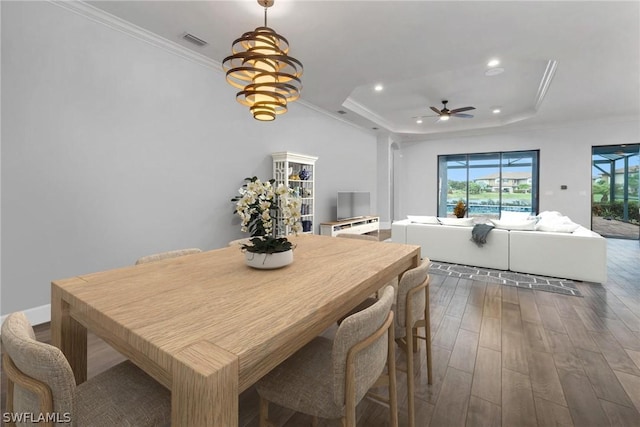 dining area featuring visible vents, crown molding, a tray ceiling, recessed lighting, and wood finished floors