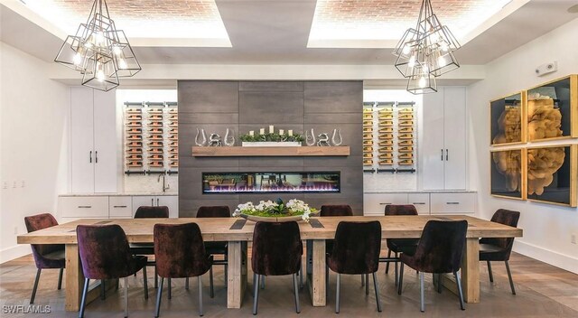 dining space with a chandelier, baseboards, and wood finished floors